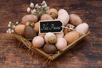 Cesta con huevos de Pascua marrones y el texto Felices Pascuas.
