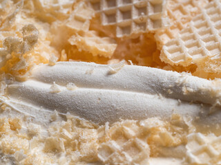 Frozen Creamy flavour gelato (called Russian Ice Cream) - full frame detail. Close up of a white surface texture of Ice cream covered with pieces of broken waffle.