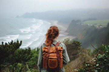 Female hiker with leather backpack looking at a coastal view. Travel and adventure concept. Design...