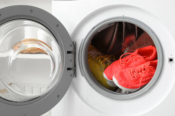 Open washing machine with sneakers, closeup