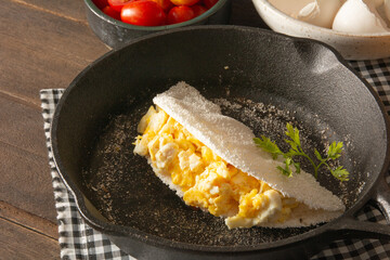 Tapioca Pancake with eggs Brazilian manioc food in top front view inside steel skillet pan