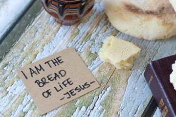 I am the bread of life - Jesus Christ, handwritten quote with holy bible book and cup of wine on...