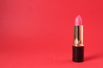 Pink lipstick on red background with space for copy space text