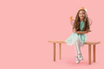 Foto op Canvas Cute little fairy with wand sitting on bench against pink background © Pixel-Shot