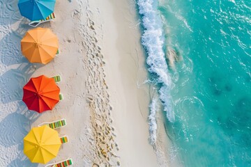 A birds eye view of a beach lined with colorful umbrellas and lounge chairs on a sunny day