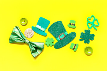 Paper leprechaun hats with bow tie and decor for St. Patrick's Day on yellow background
