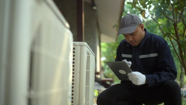 Air conditioner service outdoor checking fix repair with tablet. Air conditioner cleaning technician He opened the front cover and took out the filters and washed it. He in uniform wearing rubber.