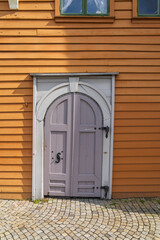 Fototapeta na wymiar Wooden House and wooden door arch in Bryggen on Bergen
