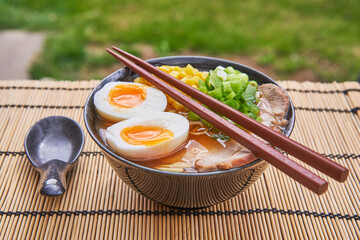 Japanese style udon or ramen soup made from pork broth and pork meat, noodles, soft boiled egg and...