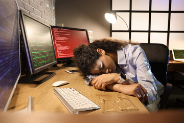 Female African-American programmer sleeping at table in office