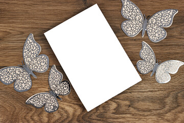 Wedding invitation card mockup decorated with butterflies on wood table. Blank card mockup