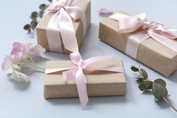 Festive wrapped gift boxes with flowers on blue background