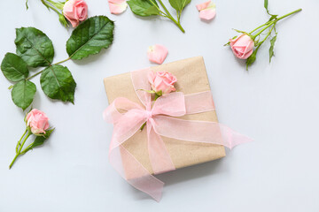 Beautiful wrapped gift box with roses on blue background