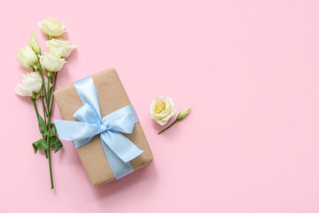 Beautiful wrapped gift box with roses on pink background