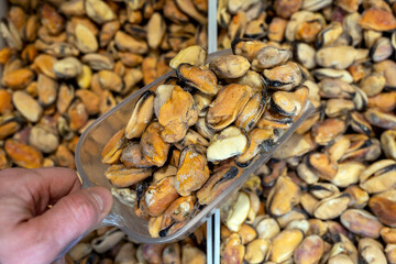 Frozen mussels. Seafood on the counter. Fish market. Close-up shooting of seafood. Photo of mussels in a supermarket. Wholesale of fish. Peeled mussels