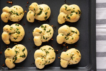 Homemade Garlic Knots with Parsley on a Baking Tray, top view.