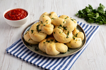 Homemade Garlic Knots with Parsley on a Plate, side view.