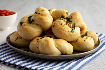 Homemade Garlic Knots with Parsley on a Plate, side view.