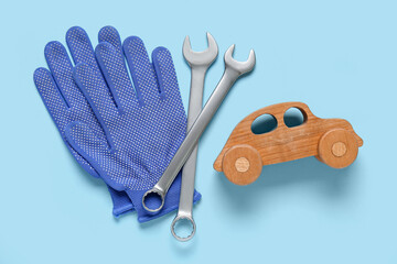 Set of mechanic tools, toy car and gloves on blue background. Mechanic concept