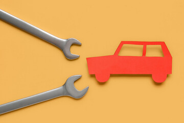 Wrenches and toy car on yellow background, closeup. Mechanic concept