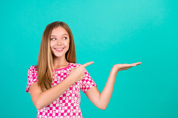 Photo portrait of nice teen woman hold point look empty space dressed stylish pink print outfit...