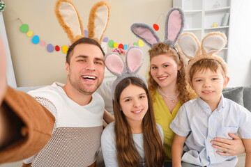 Family with Easter bunny ears taking selfie  at home
