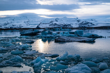 Scenic view over the icebergs in Jökulsárlón glacier lagoon under a dramatic sky, the evening...