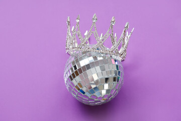 Disco ball with prom crown on purple background © Pixel-Shot