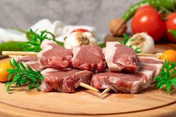 Lamb sirloin. Lamb sirloin meat skewered on a wooden serving board. Close up