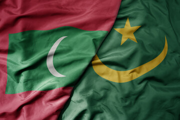 big waving national colorful flag of mauritania and national flag of maldives .