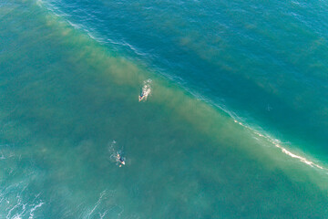 drone aerial top view of two surfers and a wave , sport in summer time concept
