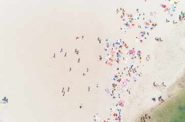 drone aerial view of people enjoying the beach in summer time