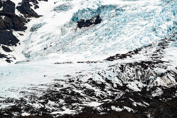 Close-up of Falljökull glacier tongue with very small depicted members of a glacier tour group,...