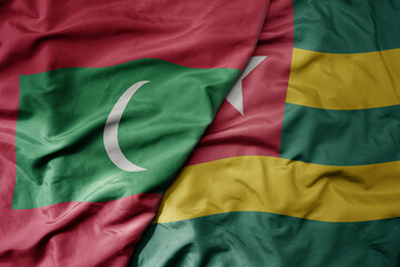 big waving national colorful flag of togo and national flag of maldives .