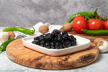 Black olive. Delicious olives grown in the Mediterranean region on a wooden serving board