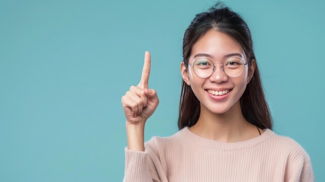 Young asian woman wearing glasses over isolated background showing and pointing up with fingers