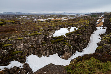 Elevated view of the snow-filled Almannagjá Gorge in late winter, seen from its northern end,...