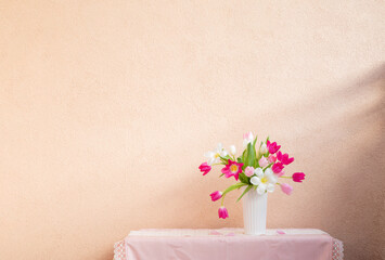 tulips in vase on table on background wall - 763603911