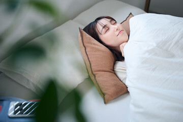 ベッドで眠る20代女性