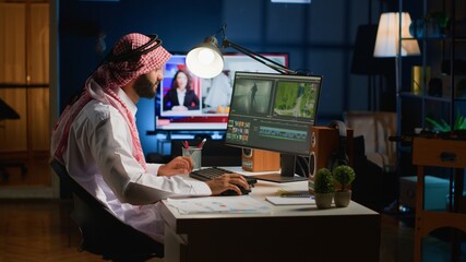 Cinematographer in home office doing post production on upcoming movie release, editing footage and...