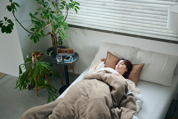 ベッドで眠る20代女性