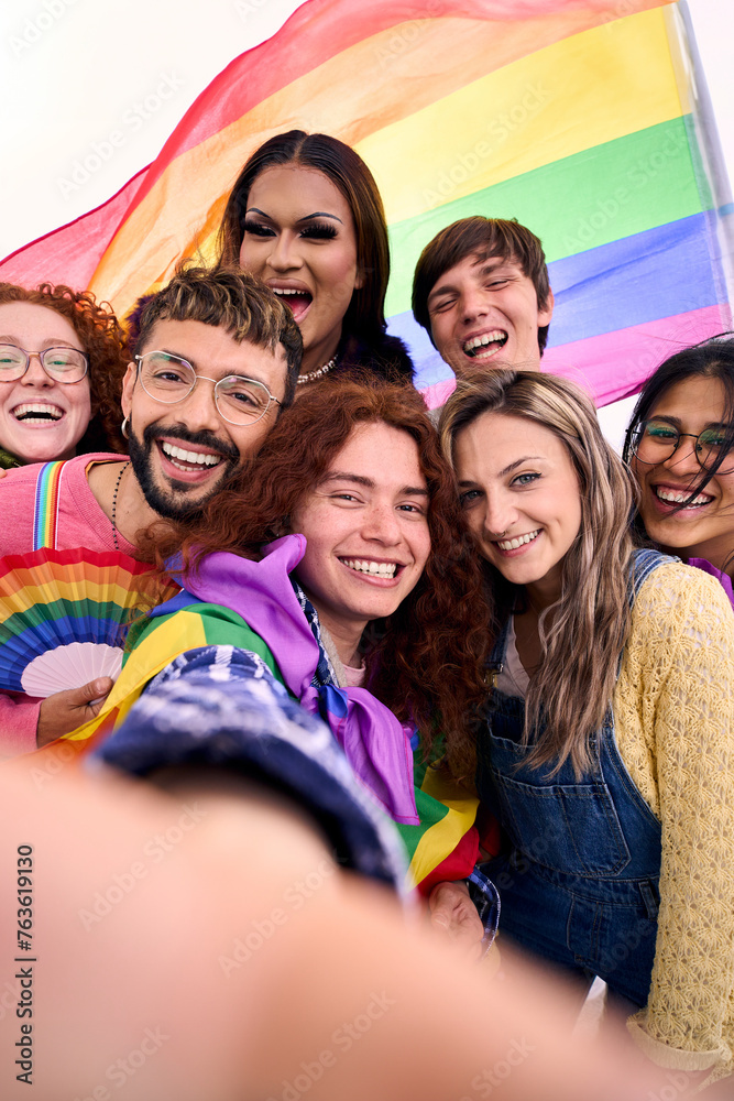 Wall mural vertical. group young diverse friends taking selfie looking at front camera of mobile celebrating ga