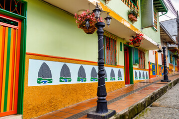 Facades of traditional colorful houses with flowers in Guatape, Colombia