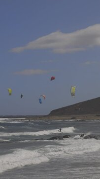 A timelapse of kite surfers on the beach in the windy town of el medano in tenerife, canary islands in vertical 