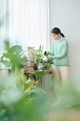 観葉植物の世話をする20代女性