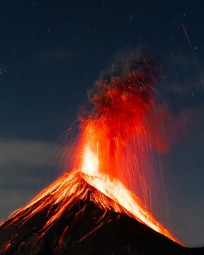 Glowing lava and smoke spitting volcano, volcanic eruption at night, Volcan de Fuego, Guatemala, Central America