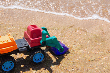 Colorful Toy Excavator on a Sandy Beach