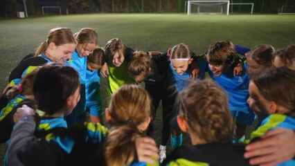 high angle view of little girls standing in a circle and talking about the strategy before match. High quality 4k footage - Powered by Adobe