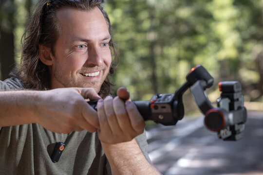 Young man filming with a phone gimbal