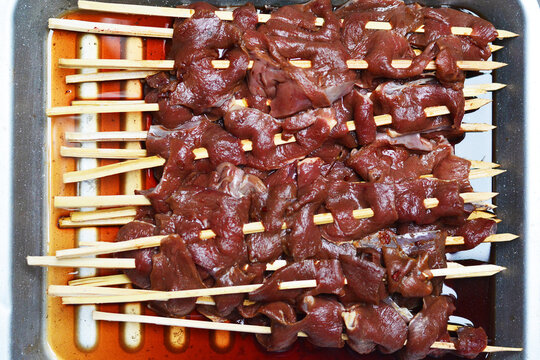Raw beef on wooden sticks. Typical peruvian food anticuchos.